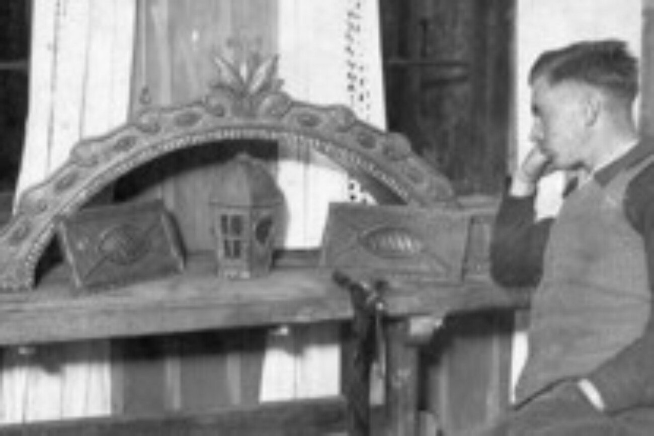 Firmengründer Ludwig Michl vor historischen handgefertigten Metallarbeiten